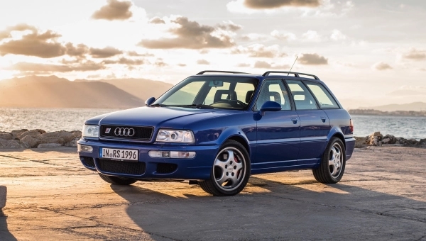 Plavi Audi RS2 Avant karavan parkiran na obali pored mora tokom zalaska sunca