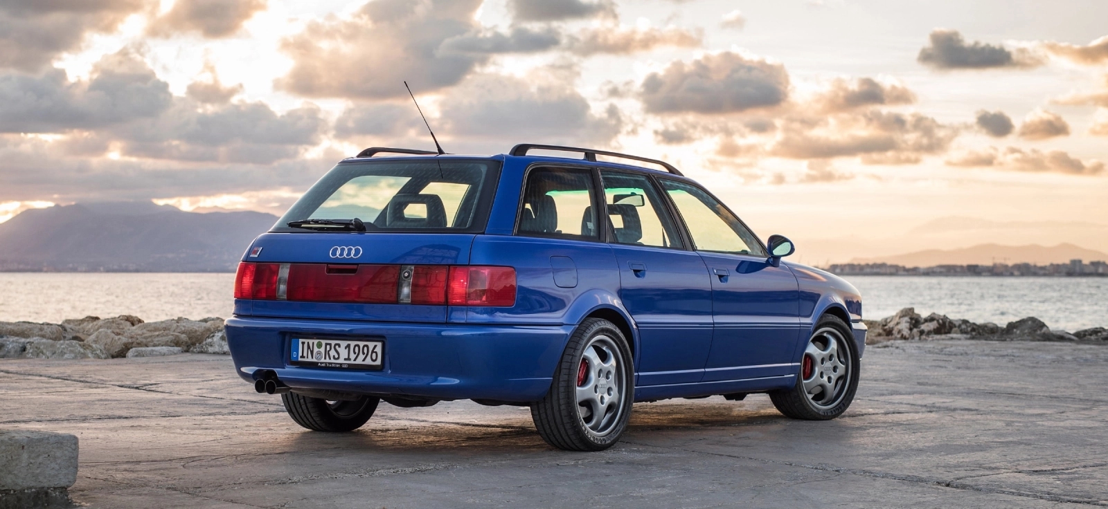 Zadnji deo karavana Audi RS2 Avant sa pogledom na svetlosnu traku i prtljažnik pored obale