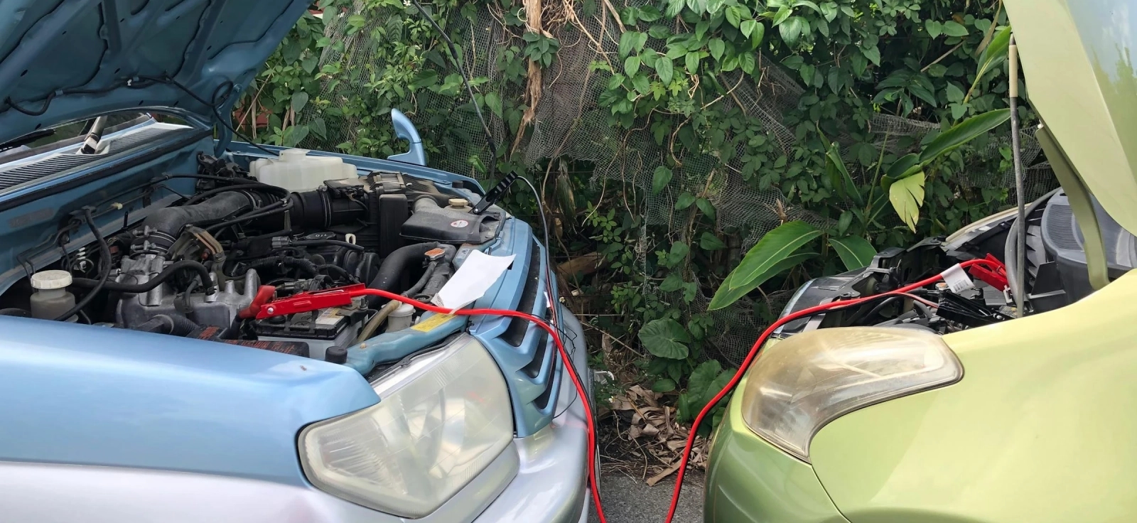 Dva automobila povezana startnim kablovima prilikom paljenja zbog praznog akumulatora