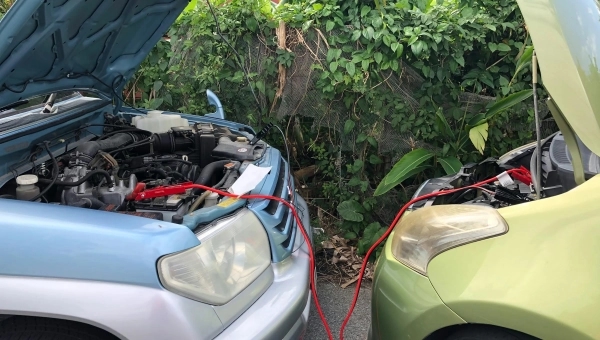 Dva automobila povezana startnim kablovima prilikom paljenja zbog praznog akumulatora