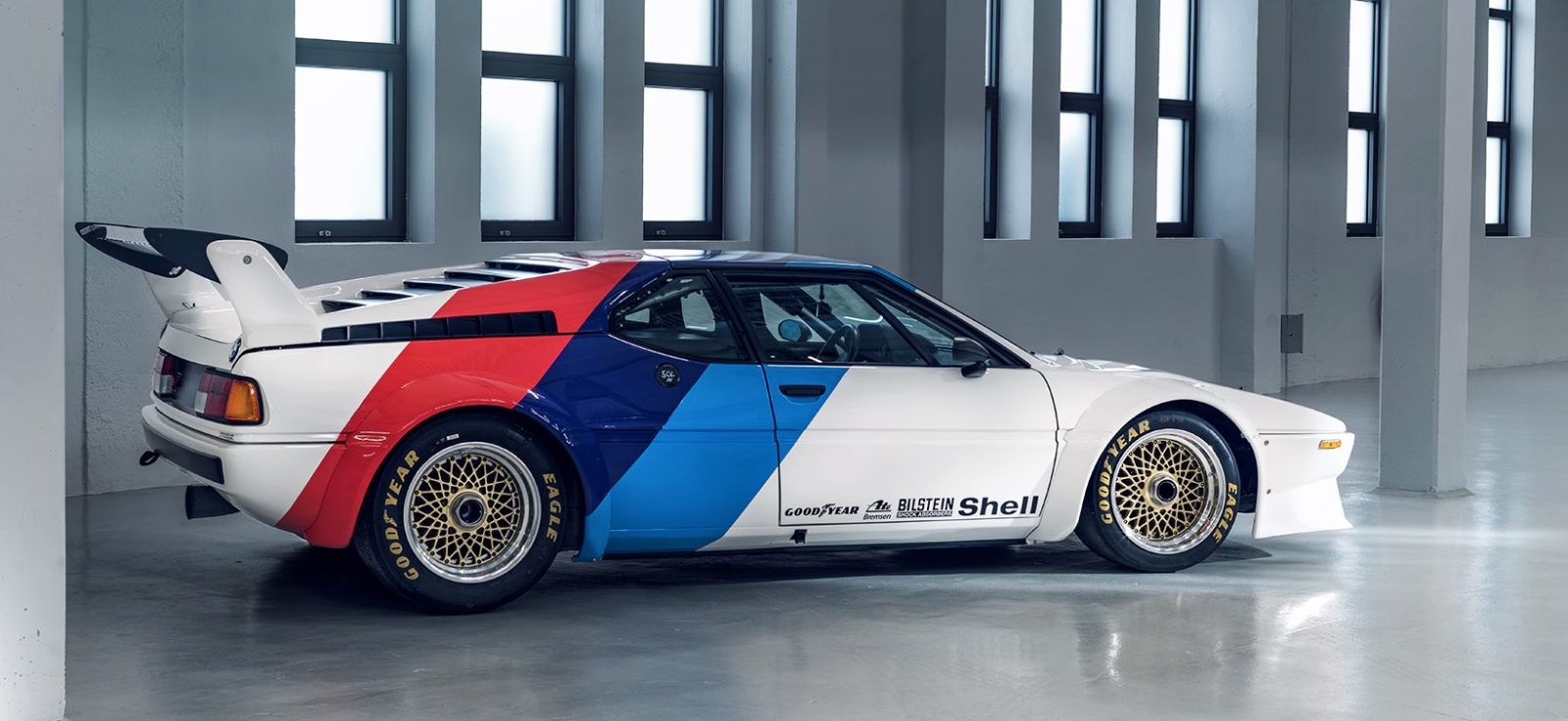 Bočni profil BMW M1 koji ističe klinasti dizajn Giorgetta Giugiara i karakteristične M boje