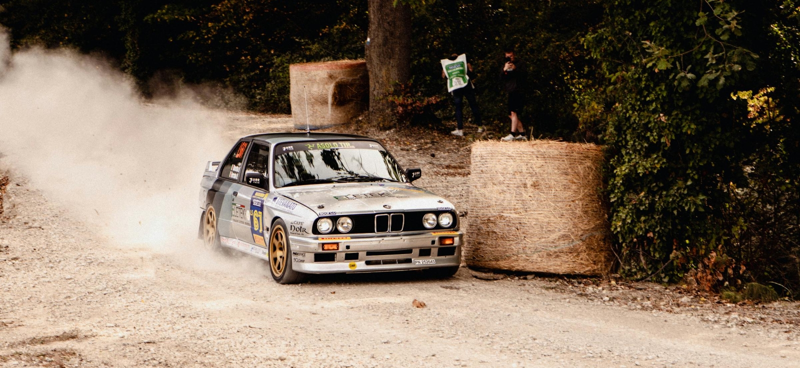 BMW M3 E30 u reli verziji proklizava na zemljanoj stazi dok publika posmatra sa strane