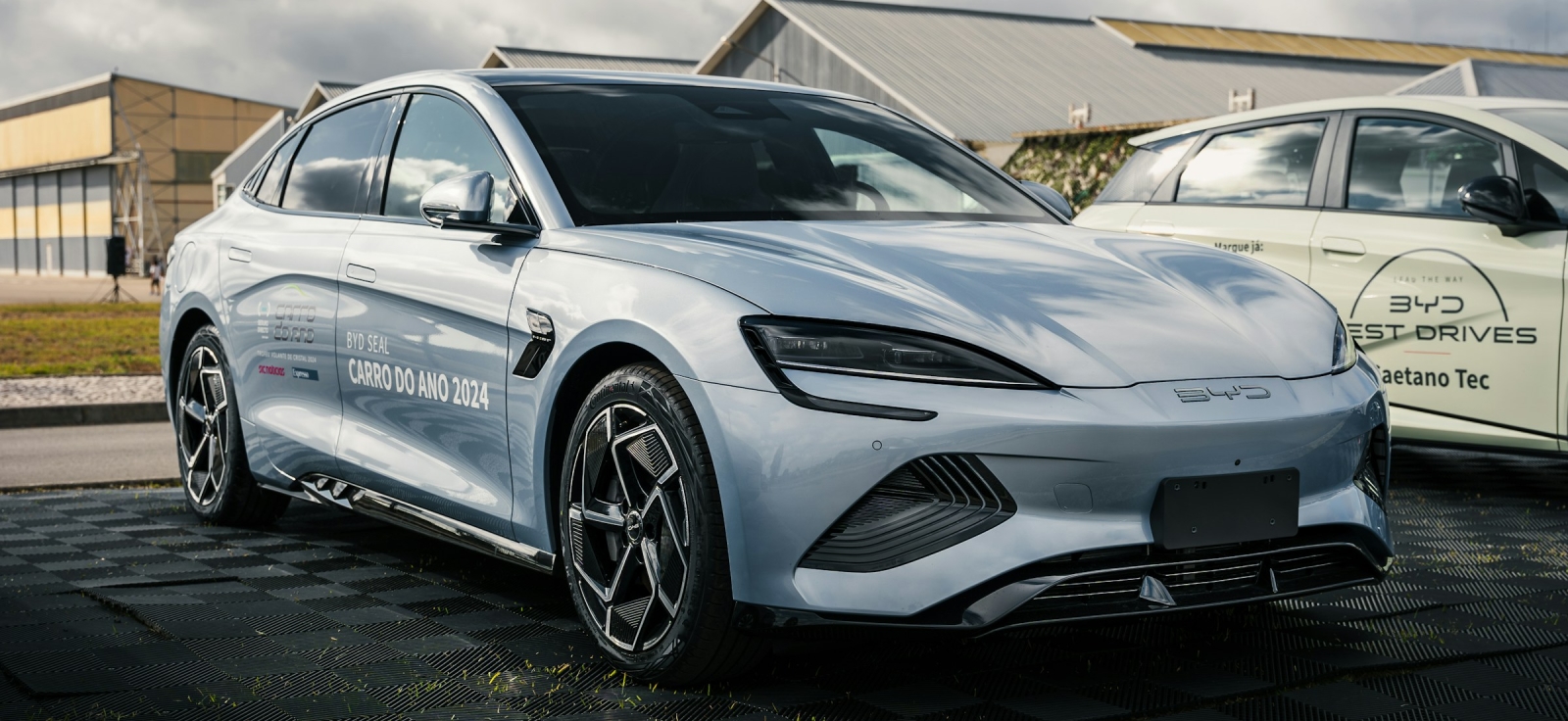 Bočni profil srebrnog BYD Seal električnog automobila parkiranog na otvorenom, sa oznakom "Automobil godine 2024" na vratima