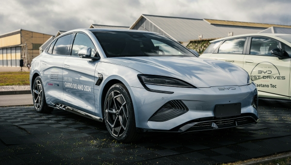 Bočni profil srebrnog BYD Seal električnog automobila parkiranog na otvorenom, sa oznakom "Automobil godine 2024" na vratima