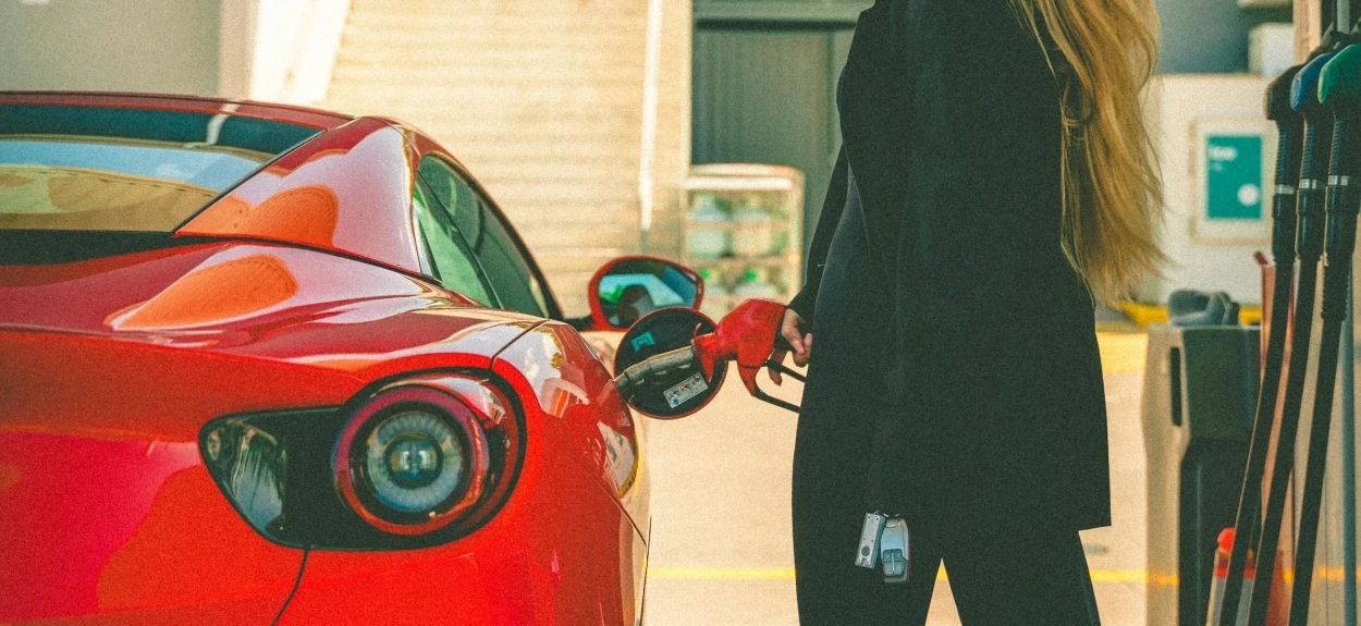 Vozač sipa premium gorivo u sportski automobil na modernoj benzinskoj pumpi, ilustracija razlike između skupljeg i jeftinijeg goriva