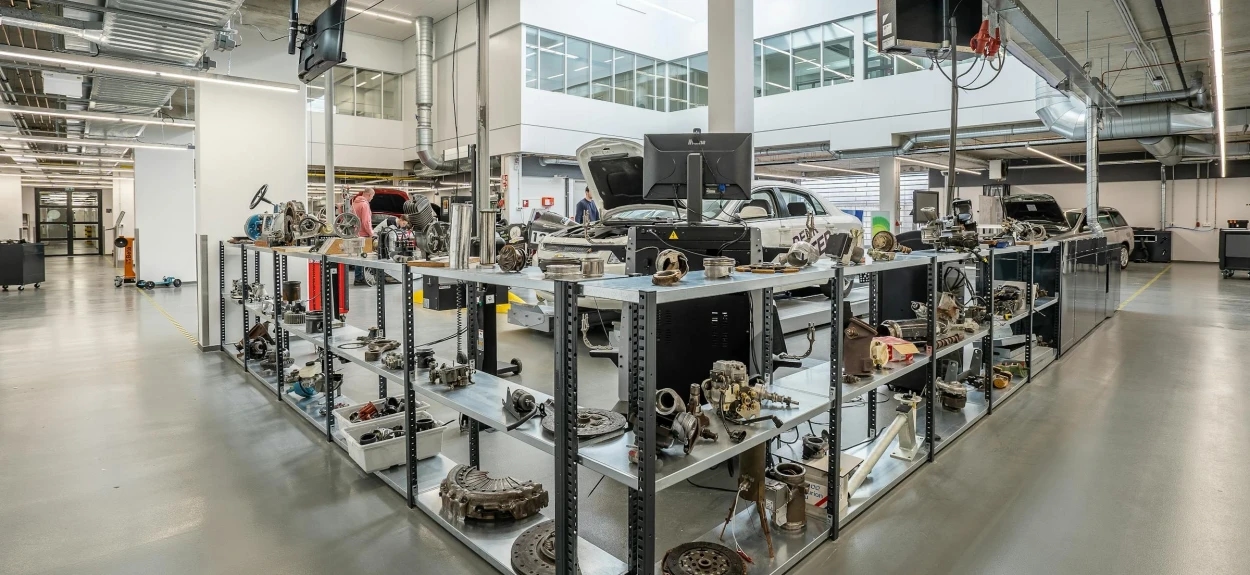 Radionica puna autodelova koji su raspoređeni po policama.