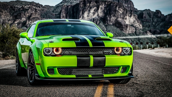 Prednji profil zelenog Dodge Challenger SRT Hellcat-a sa crnim prugama na asfaltu – ikona moderne muscle kulture sa 707 konjskih snaga