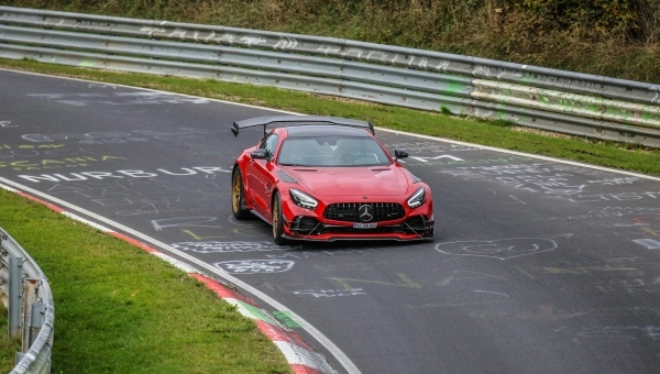 Crveni automobil marke Mercedes na trkačkoj stazi.