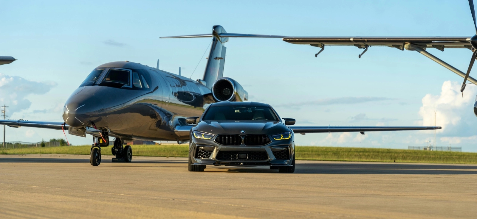 BMW parkiran pored malog aviona, simbol povezanosti brenda sa avio-industrijom iz koje je nastao