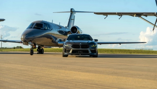BMW parkiran pored malog aviona, simbol povezanosti brenda sa avio-industrijom iz koje je nastao