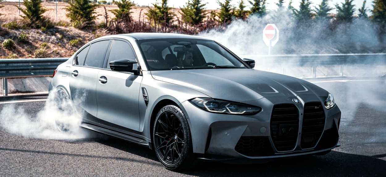 BMW M3 u drifitngu na asfaltu, sportska limuzina koja prikazuje snagu i performanse modernih BMW modela