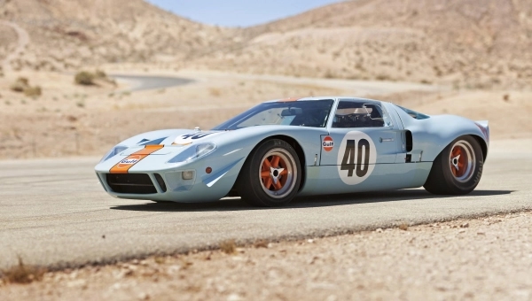 Klasični Ford GT40 Mk I u Gulf plavo-narandžastoj boji na trkačkoj stazi, legenda rivalstva Ford vs Ferrari i simbol pobede na Le Mansu