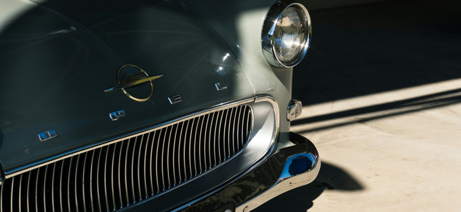 Krupni kadar prednjeg dela oldtajmer automobila Opel sa prepoznatljivim starim logotipom i hromiranom maskom hladnjaka