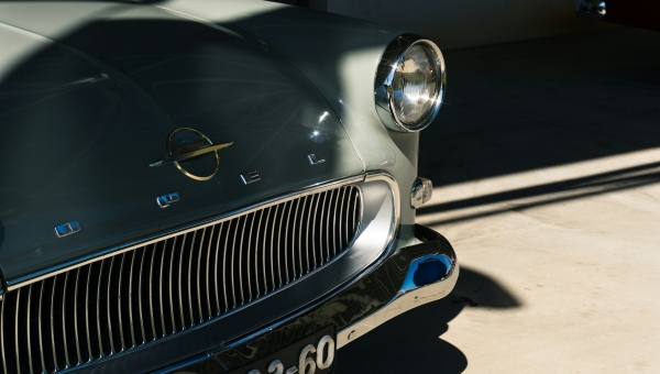 Krupni kadar prednjeg dela oldtajmer automobila Opel sa prepoznatljivim starim logotipom i hromiranom maskom hladnjaka