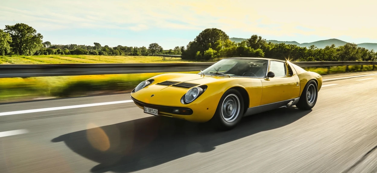 Legendarna žuta Lamborghini Miura u brzoj vožnji na putu, prvi superautomobil sa centralno postavljenim motorom