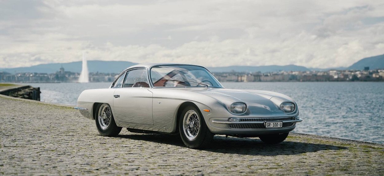 Srebrni Lamborghini 350 GT, prvi serijski model kompanije, parkiran pored jezera