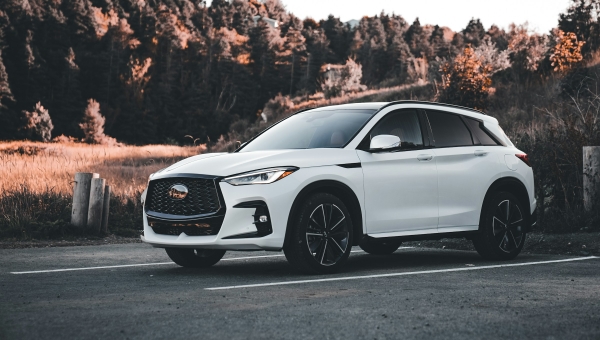 Beli luksuzni SUV parkiran na čistom prostoru kao primer idealne fotografije za oglas