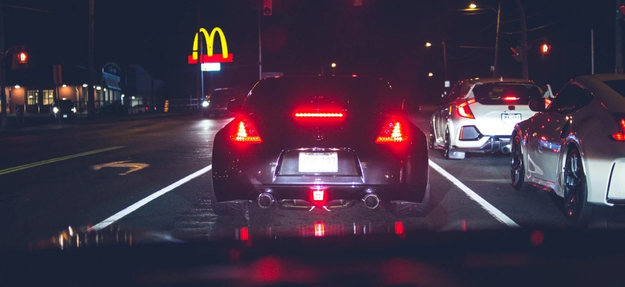 Pogled iz automobila na nocni put na semaforu.