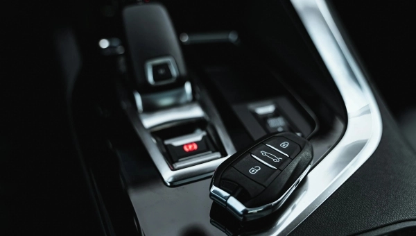 Crni enterijer luksuznog automobila sa ključem pored menjača.