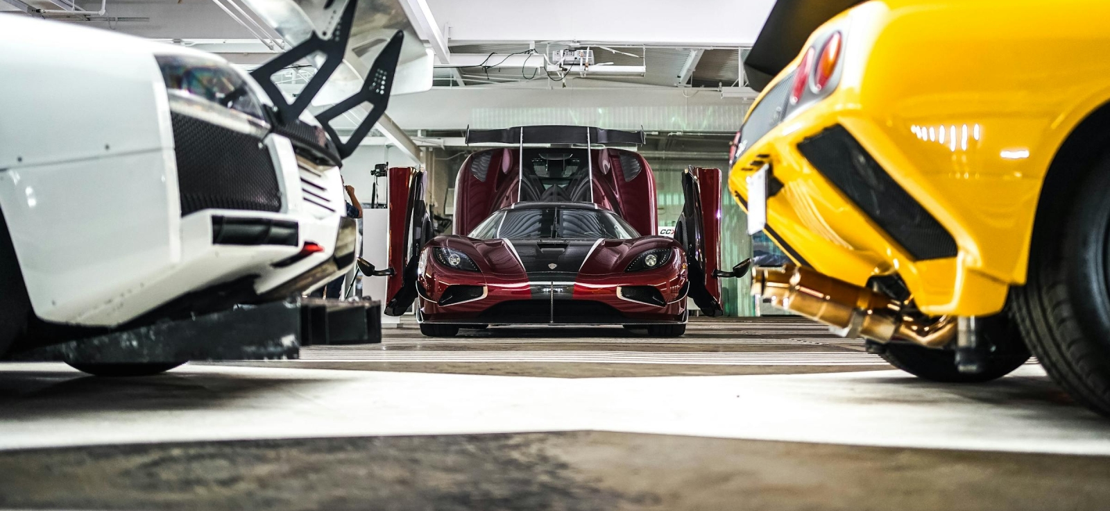 Ekskluzivna garaža sa bordo Koenigsegg Agera modelom i žutim Lamborghinijem, prikaz vrhunskog inženjeringa i dizajna