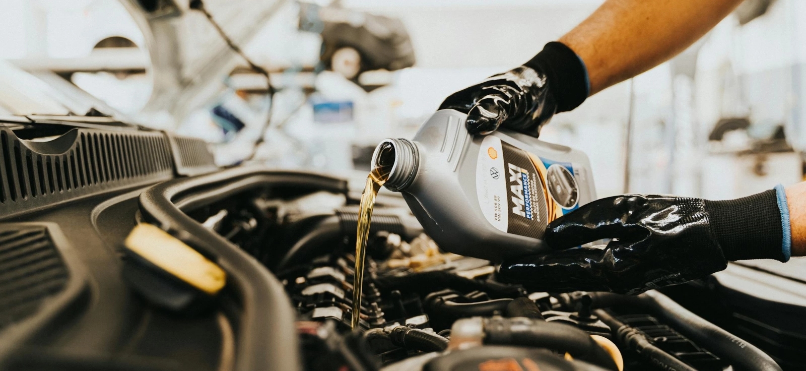 Sipanje novog motornog ulja tokom malog servisa automobila u auto servisu