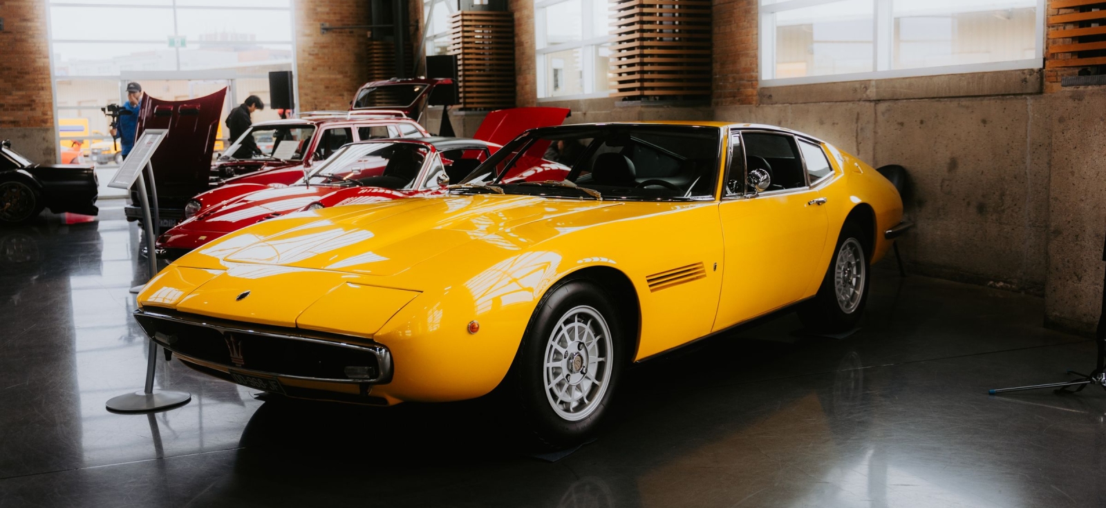 Klasik Maserati Ghibli u žutoj boji izložen u modernom salonskom prostoru