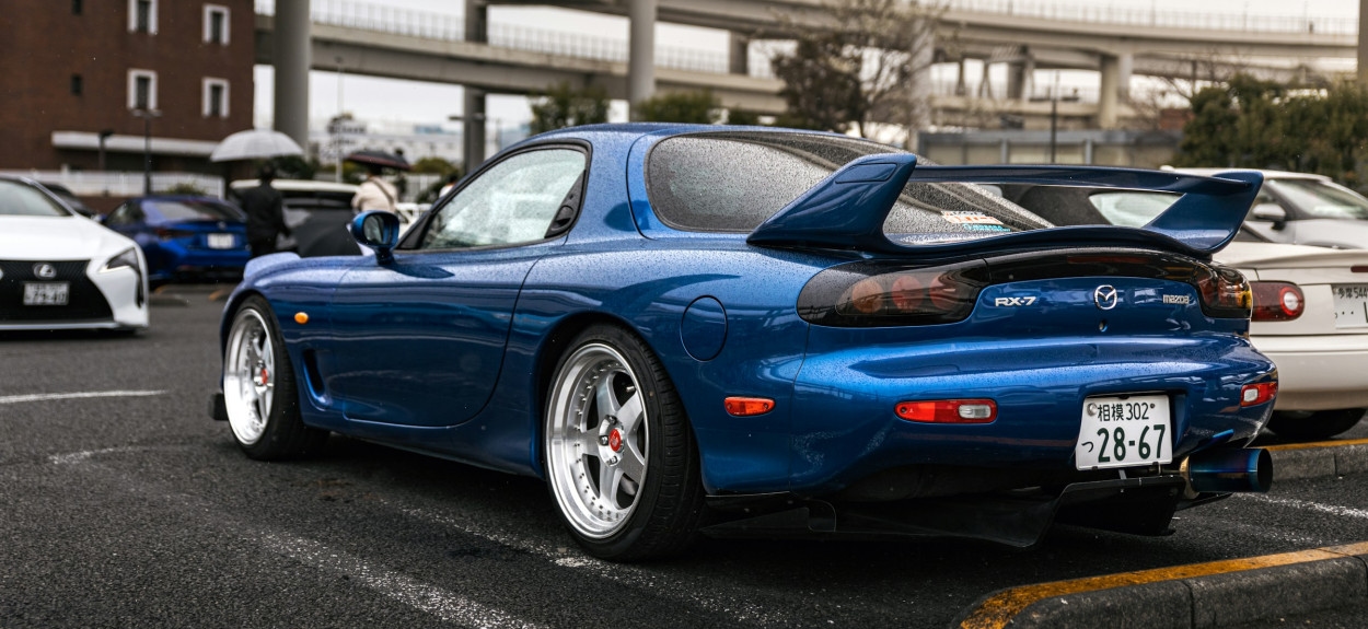 Zadnji deo plave Mazde RX-7 FD koja pokazuje prepoznatljiva stop svetla i veliki sportski spojler