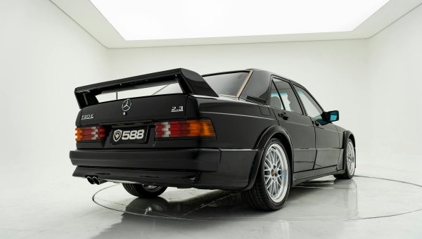 Crni Mercedes-Benz 190E 2.3-16 Cosworth sa karakterističnim zadnjim spojlerom i višestrukim aluminijumskim felnama u studiju