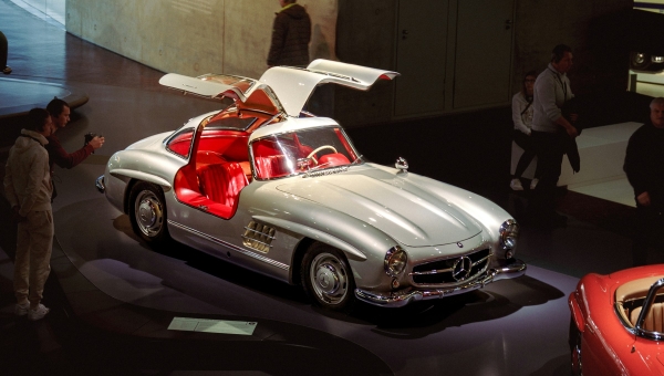 Srebrni Mercedes Benz 300SL Gullwing sa otvorenim galebovim krilima i crvenim kožnim sedištima u muzeju