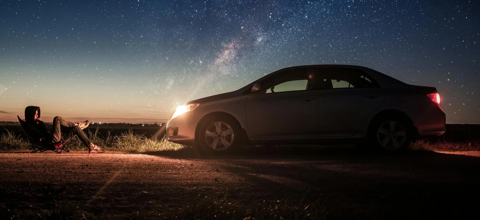 Automobil parkiran noću pod zvezdanim nebom ilustruje automobilske mitove