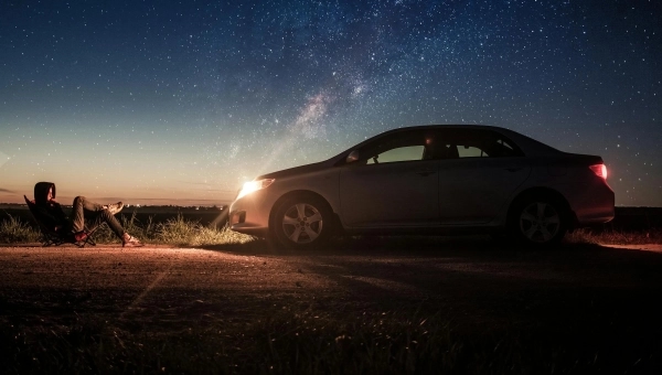Automobil parkiran noću pod zvezdanim nebom ilustruje automobilske mitove