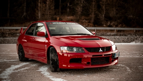 Mitsubishi Lancer Evolution IX crveni sportski automobil parkiran na asfaltu