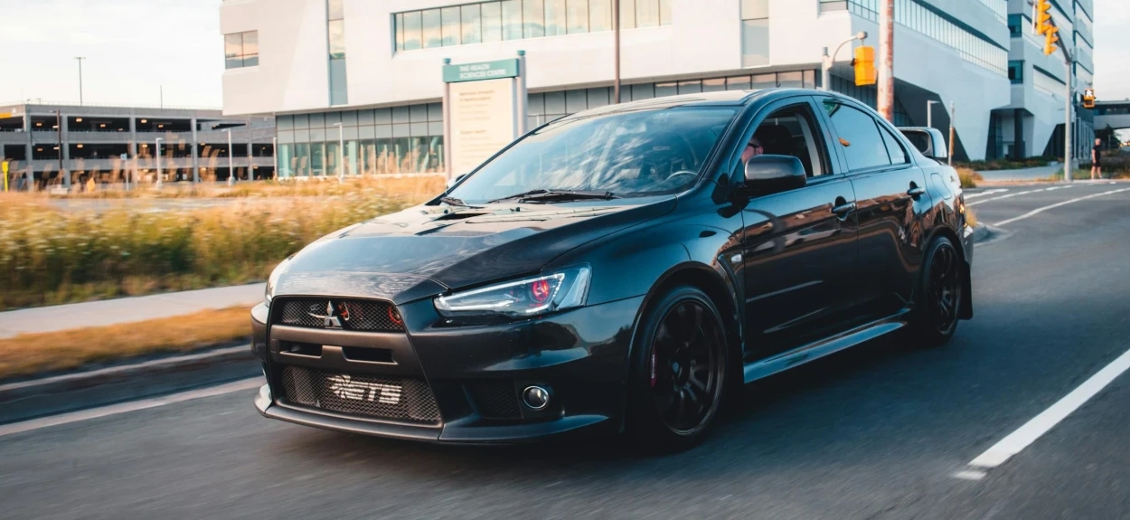 Mitsubishi Lancer Evolution X crna sportska limuzina u gradskoj vožnji