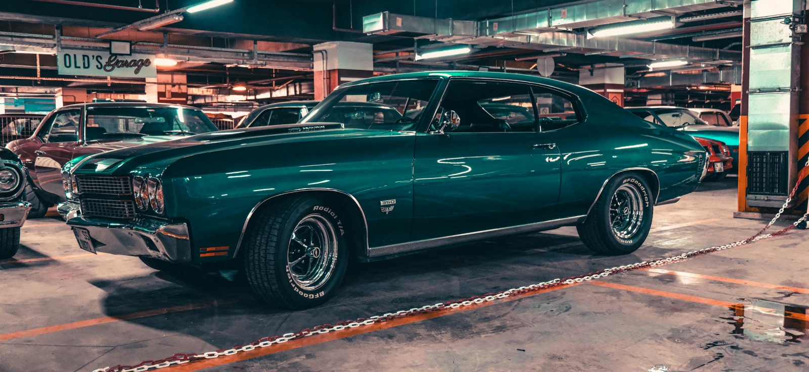 Tamnozeleni američki mišićavi automobil parkiran u garaži kao simbol ere pre naftnog šoka 1973