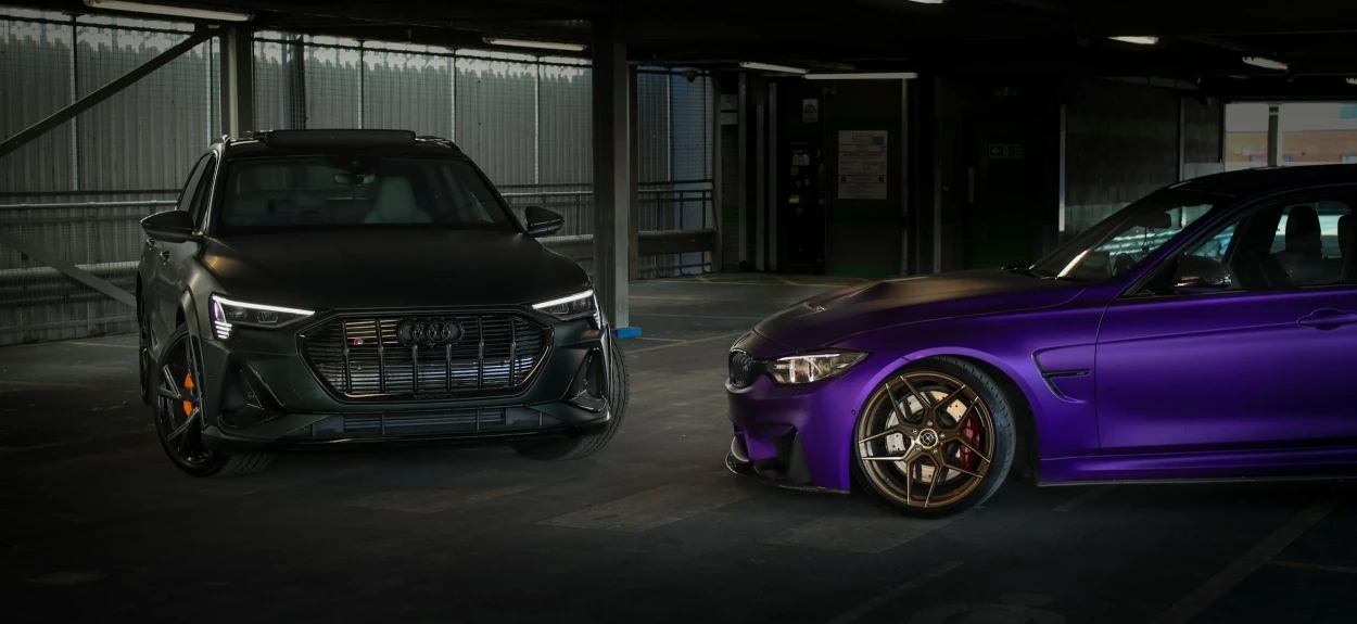 Audi i BMW sportski automobili u garaži koji predstavljaju tehnološko rivalstvo nemačkih brendova