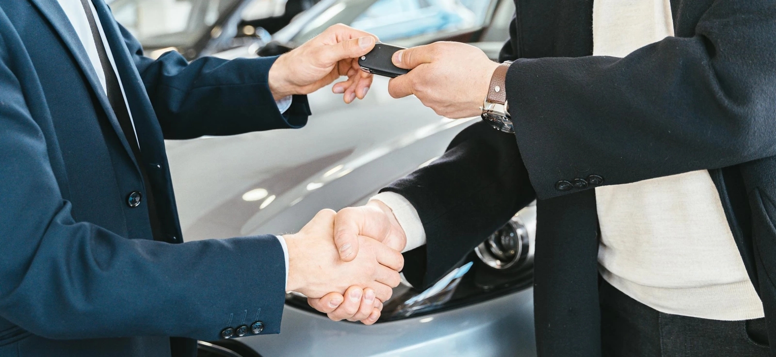 Kupac i prodavac se rukuju prilikom predaje ključeva polovnog automobila nakon uspešne provere