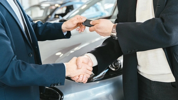 Kupac i prodavac se rukuju prilikom predaje ključeva polovnog automobila nakon uspešne provere