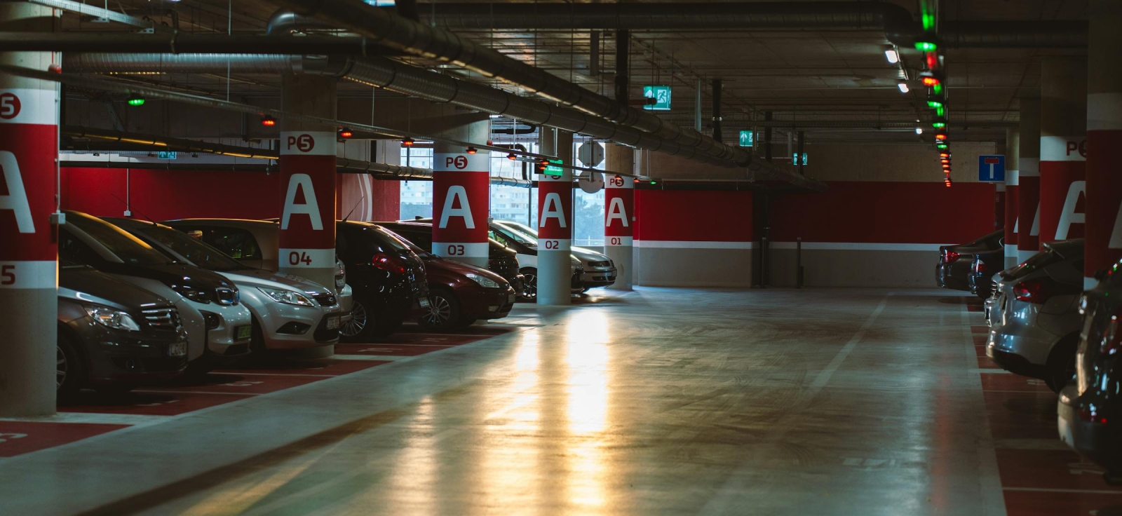 Automobili parkirani u osvetljenoj garaži spremni za proveru ispravnosti i registraciju