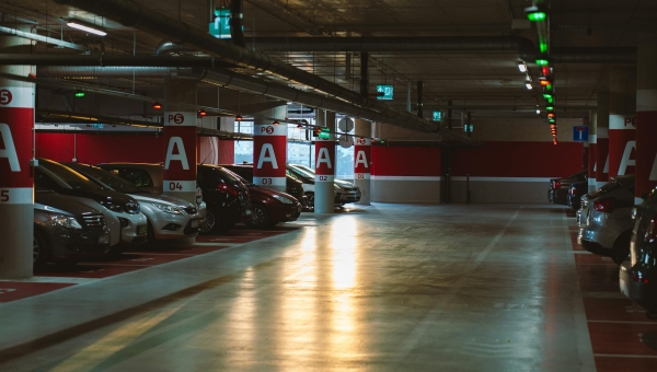 Automobili parkirani u osvetljenoj garaži spremni za proveru ispravnosti i registraciju