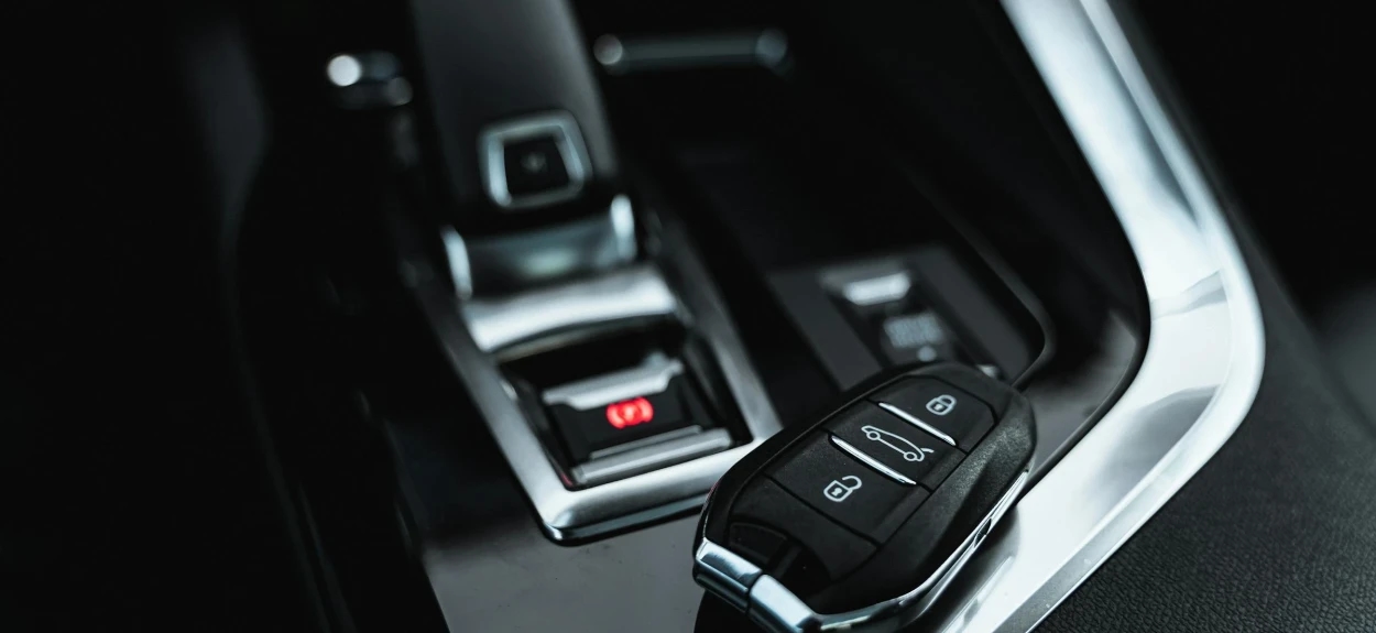 Crni enterijej luksuznog auta sa klječem pored menjača.