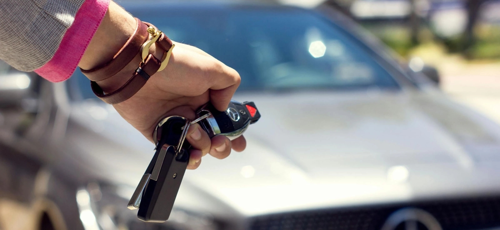 Devojka koja otključava svoj auto marke Mercedes iz daljine.