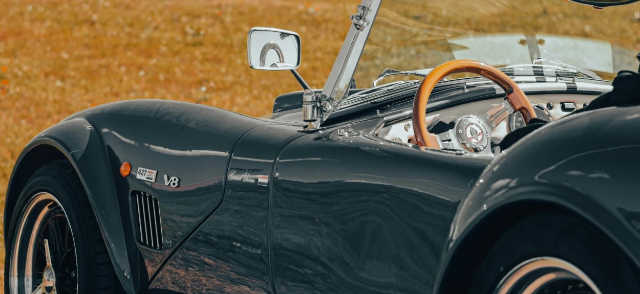 Detalj Shelby Cobra 427 iz bočnog ugla sa vidljivim izduvom, zadnjim točkom i minimalističkim enterijerom trkačke ikone