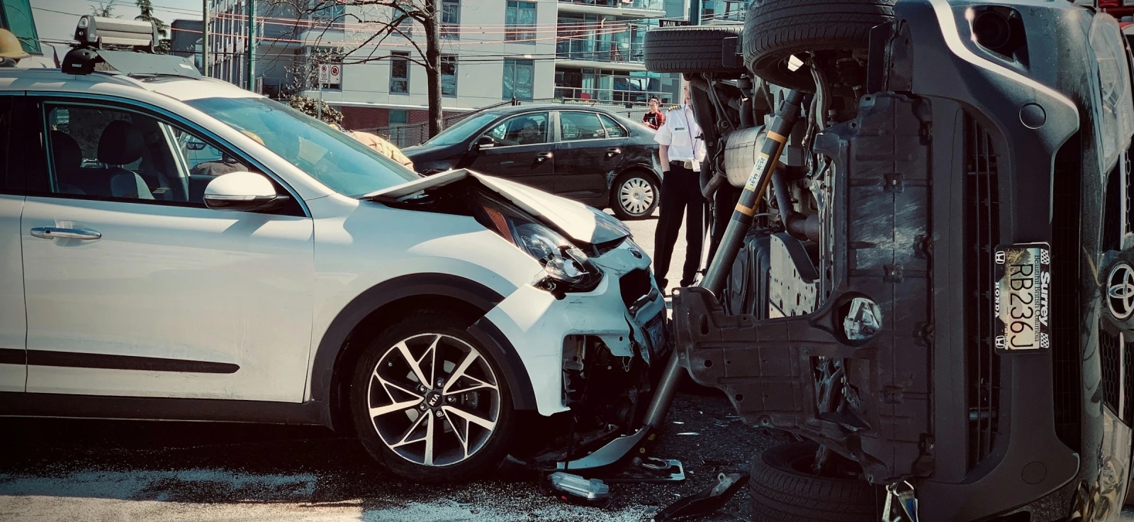 Saobraćajna nezgoda u gradu, dva automobila sudarena, jedno vozilo prevrnuto nakon udesa
