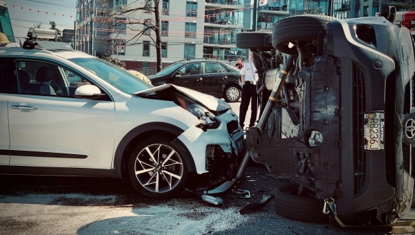 Saobraćajna nezgoda u gradu, dva automobila sudarena, jedno vozilo prevrnuto nakon udesa