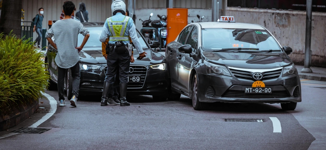 Policajac na uviđaju sa učesnicima saobraćajne nezgode na gradskom putu