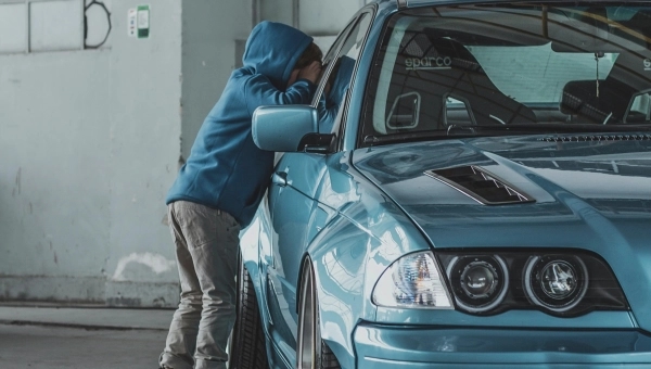 Dete u plavom duksu gleda kroz auto kako bi videlo njegovu unutrašnjost.