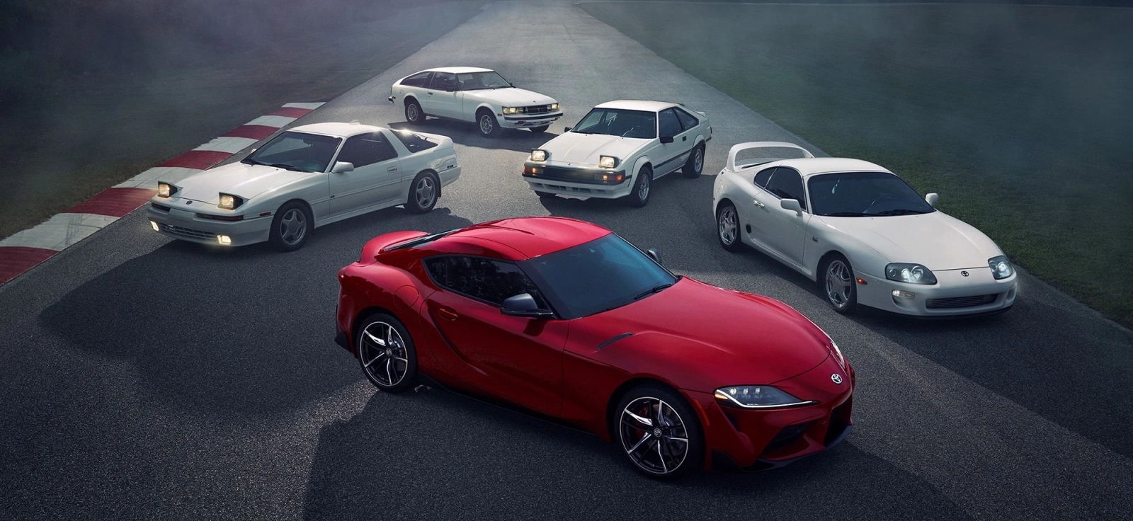 Sve generacije Toyota Supre – od MK1 do MK5 parkirane na stazi, sa crvenom A90 u prvom planu