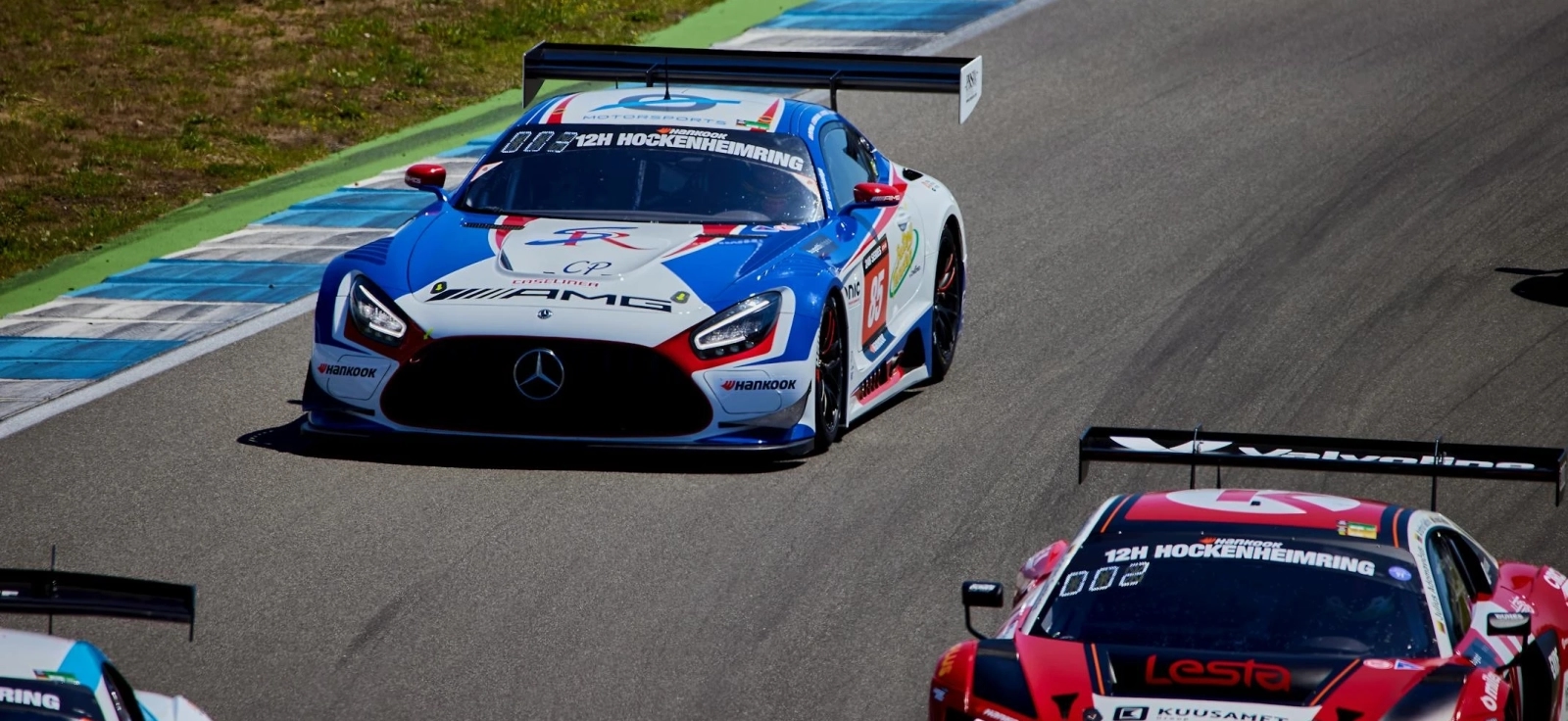 Prikaz automobilske trka sa fokusom na automobil marke Mercedes na stazi.