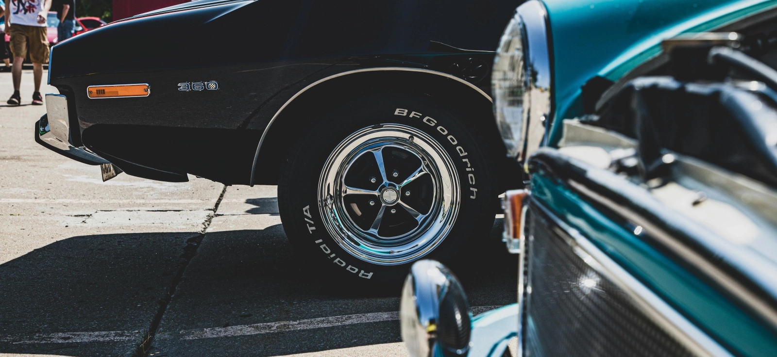 Crni automobil stare američke marke u fokusu sa visokoprofilnim gumama.