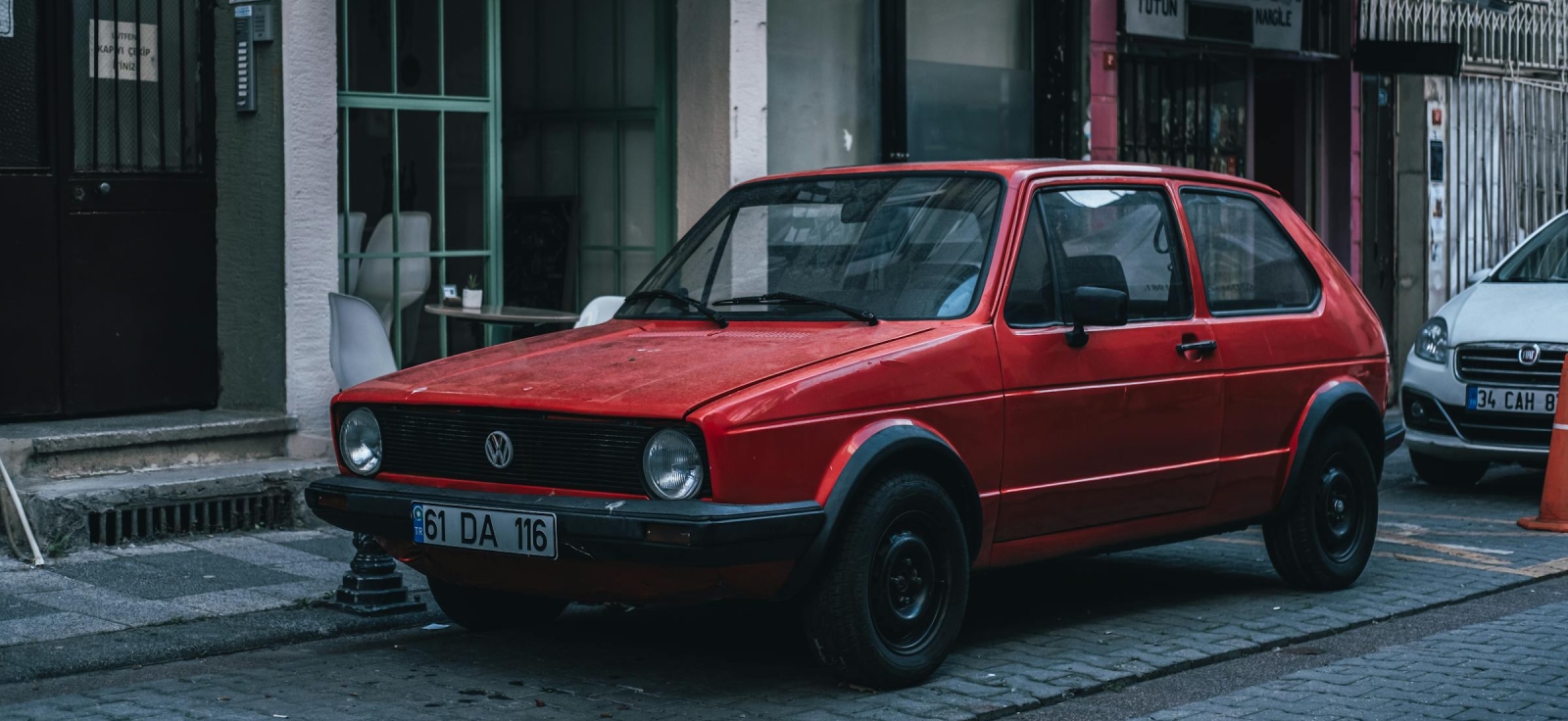 Restaurirani crveni Volkswagen Golf 1 parkiran ispred gradskog lokala
